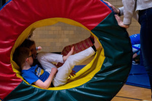 Two kids in center of rolling donut shaped gym equipment