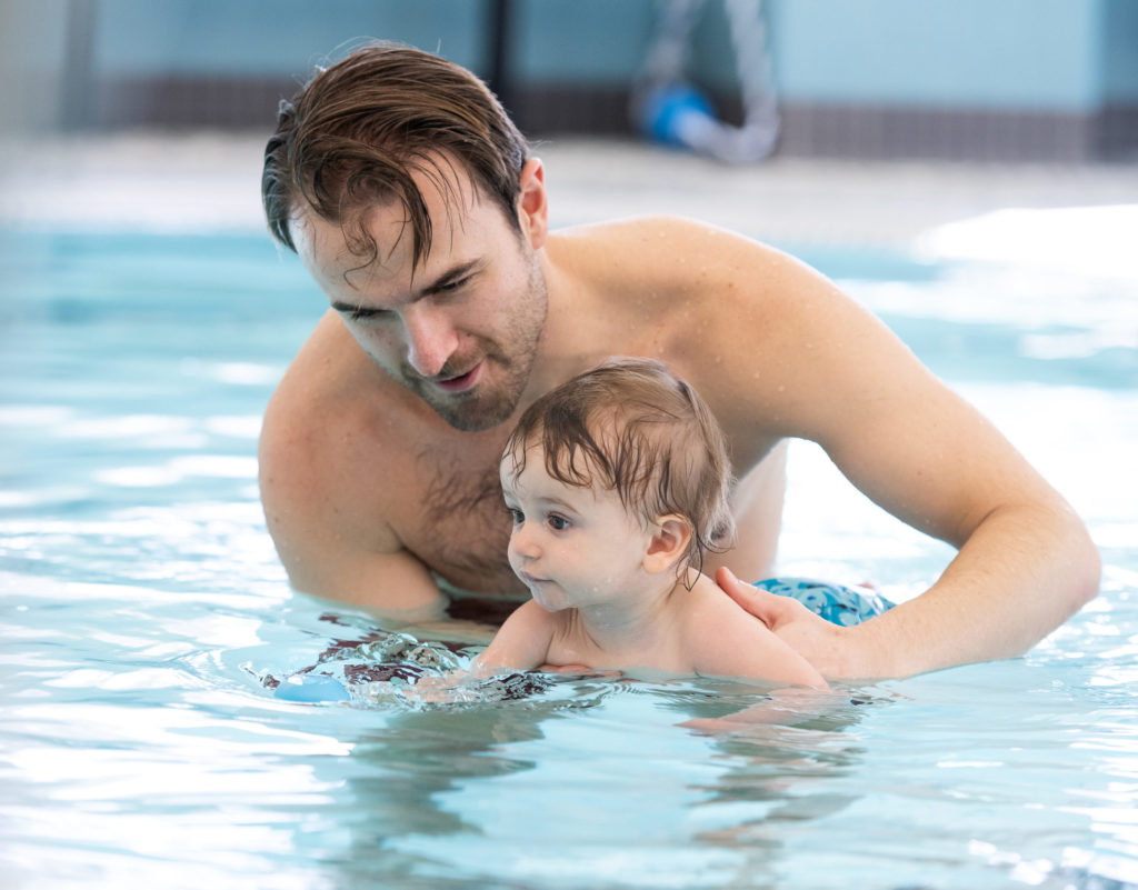 Dad helping young child in GBYMCA swim lesson