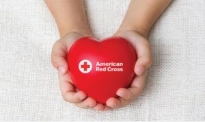 Hands holding a heart with an American Red Cross logo